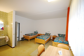 Das Bild zeigt die Betten in einem Internatszimmer.