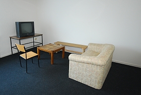 Das Bild zeigt Sessel, Tische und den Fernseher im Fernsehraum.