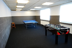 Das Bild zeigt einen Freizeitraum mit Tischfußball und Tischtennisplatte