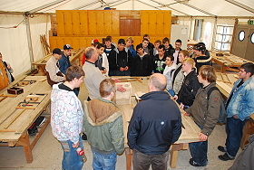 Das Bild zeigt eine Schulklasse beim Rundgang durch die Betonbauerwerkstatt.