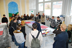 Das Bild zeigt eine Schulklasse beim Rundgang. Herr Hoffmann erklärt den Beruf des Stuckateurs.