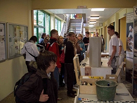 Das Bild zeigt eine Schulklasse, die sich die Arbeit der Stuckateure ansieht.