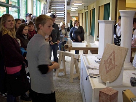 Eine Schulklasse informiert sich, über die Arbeit des Stuckateurs.